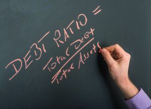 debt ratio on blackboard with hand