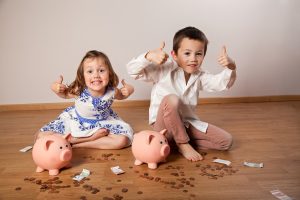 Brother and sister sitting among banknotes and showing ok