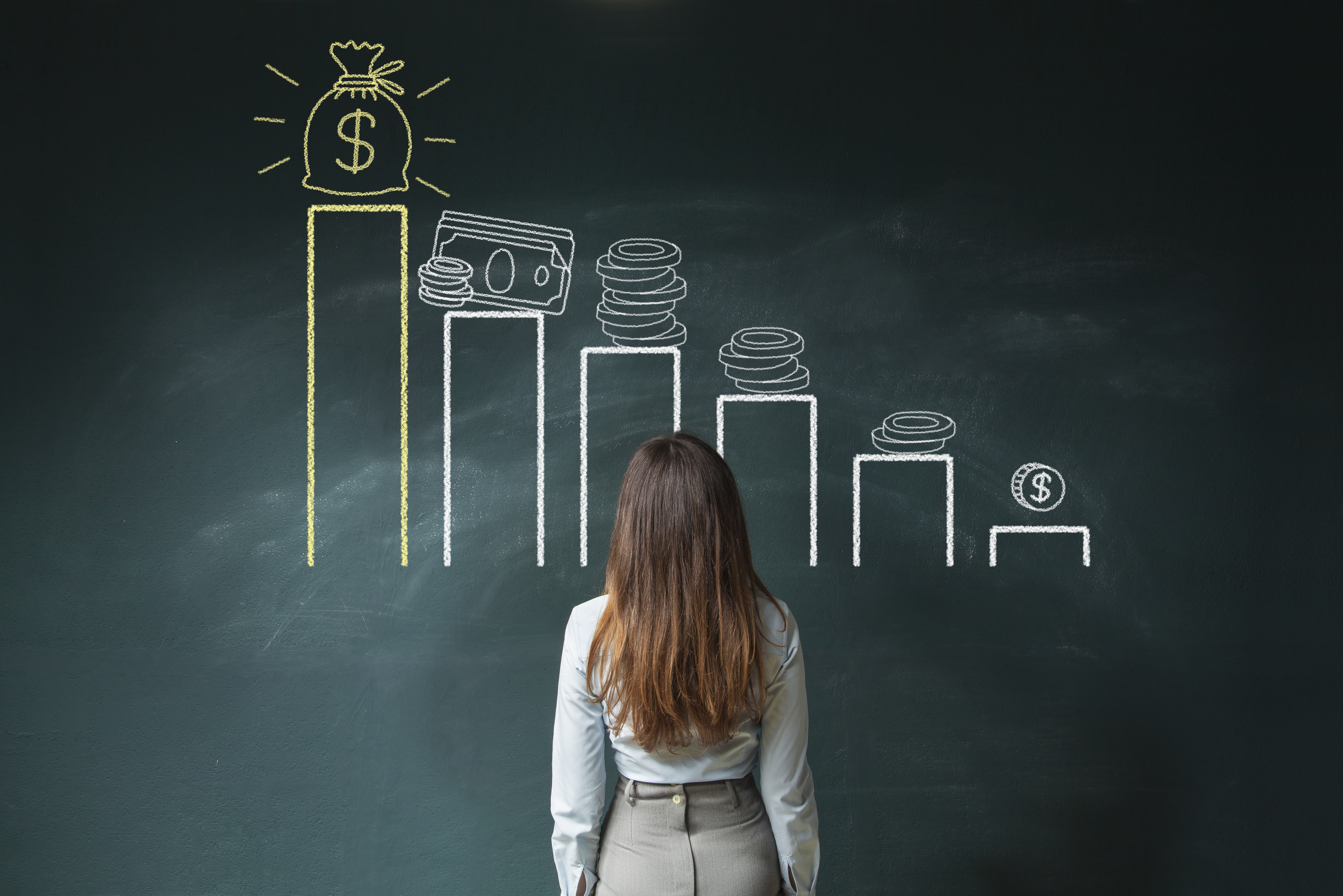 Business woman standing in front of a blackboard with a financial chart